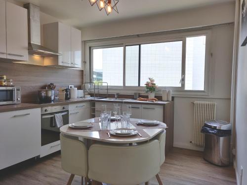 - une cuisine avec une table et des verres dans l'établissement Appart'HomeCity - Rouen Grand Prieuré, à Rouen