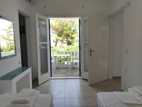 a room with two beds and a door to a patio at Superior Beach in Pefkohori