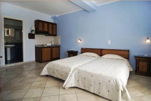 a bedroom with a large bed and a blue wall at Dias Studios in Pythagoreio