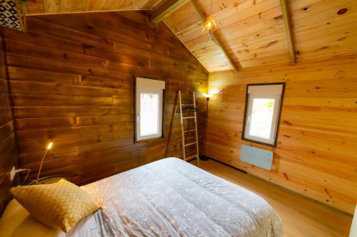 Un dormitorio con paredes de madera y una cama en una habitación. en LA CABAÑA Del Camino, en Mazaricos
