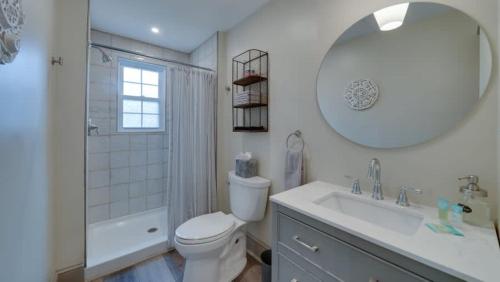 uma casa de banho com um WC, um lavatório e um espelho. em The Suite in a historic carriage house em Kennett Square