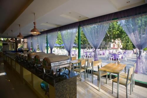 un restaurante con mesas y sillas y una gran ventana en Beidaihe No. 3 Jinhai, en Qinhuangdao