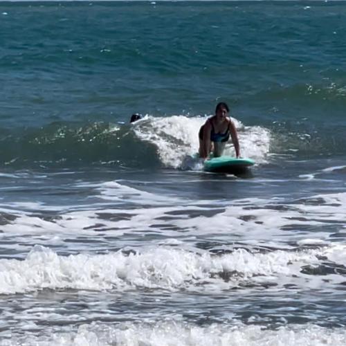 a woman riding a wave on a surfboard in the ocean at älanacasadeplaya in San Bernardo del Viento