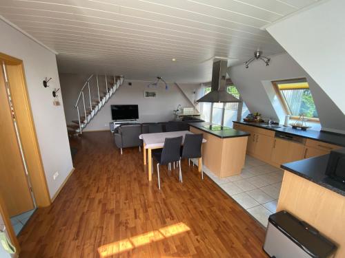 a kitchen and living room with a table and chairs at Moderne Maisonette-Wohnung am Karpfenteich; modern Apartment with view of the carp pond in Barmstedt