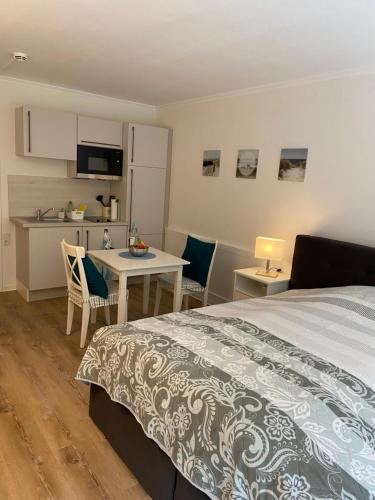 1 dormitorio con cama, mesa y cocina en Glück am Meer en Glücksburg