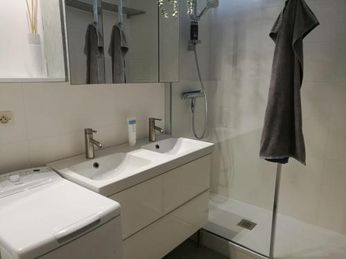 une salle de bain blanche avec deux lavabos et une douche dans l'établissement Nicolas III, parking privé, clim, balcon, à Grenoble