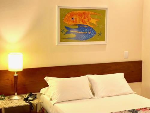 a bedroom with a bed and a painting on the wall at Kastel Manibu Recife - Boa Viagem in Recife