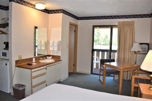 Habitación de hotel con baño con lavabo y escritorio. en Winthrop Inn, en Winthrop
