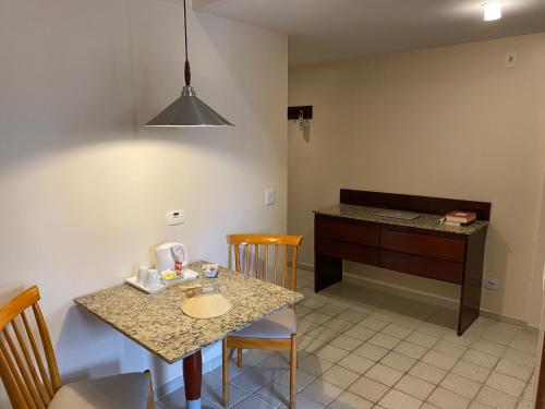 a kitchen with a table and chairs and a desk at Kastel Manibu Recife - Boa Viagem in Recife