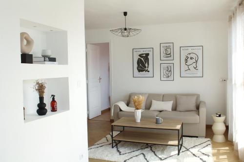 a living room with a couch and a coffee table at Cocon Perret - Plage du Havre - Design & Moderne in Le Havre