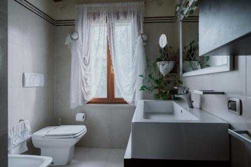 a bathroom with a toilet and a sink and a window at Casa Polè in Bagnolo San Vito