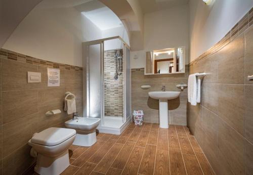 a bathroom with a toilet and a sink and a shower at Il Glicine Appartamenti & Rooms in Castellammare del Golfo