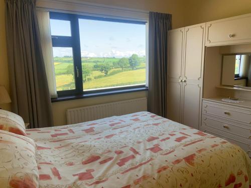 a bedroom with a bed and a large window at Gracey's Hillside Lodge in Ballyward