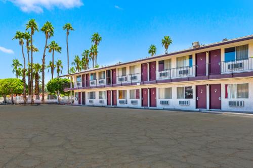 un gran edificio con palmeras en el fondo en Knights Inn Yuma, en Yuma