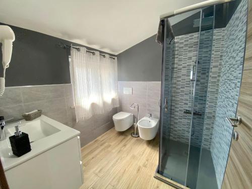 a bathroom with a shower and a sink and a toilet at Cadoni Guest House in Bosa