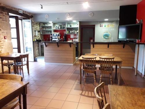 um restaurante com mesas e cadeiras e um bar em Le Tromp' L'Œil em Vitrac
