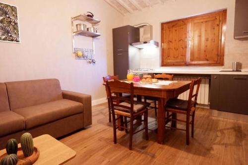 a kitchen and dining room with a table and a couch at Il Villino del Daino - Toscana in Loro Ciuffenna