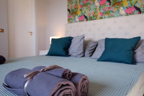 a bed with blue pillows and a blanket on it at Il Villino del Daino - Toscana in Loro Ciuffenna