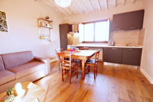 a kitchen and dining room with a table and a couch at Il Villino del Daino - Toscana in Loro Ciuffenna