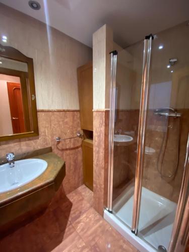 y baño con ducha y lavamanos. en Apartamento FERIA CENTRO Albacete, en Albacete