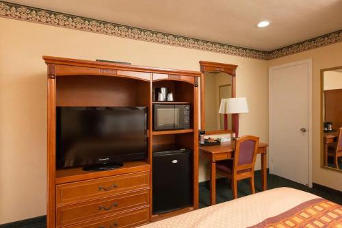 a hotel room with a bed and a television and a desk at Geary Parkway Motel in San Francisco