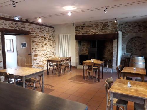a restaurant with wooden tables and chairs and brick walls at Le Tromp' L'Œil in Vitrac