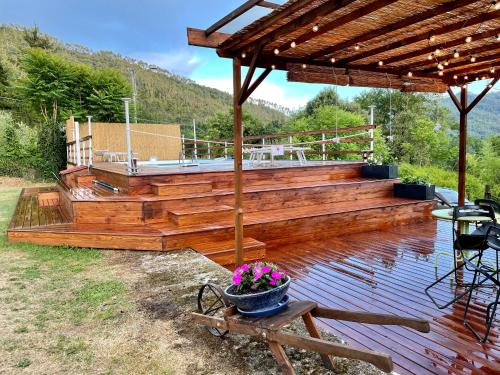 a wooden deck with a bench and a pot of flowers at Impronte Nel Bosco in Calice al Cornoviglio