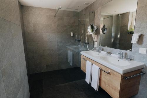 a bathroom with a sink and a mirror at Wellnesshotel Schweizerhof in Saas-Fee