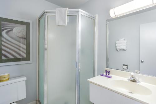 a bathroom with a shower and a sink and a mirror at Knights Inn and Suites Yuma in Yuma