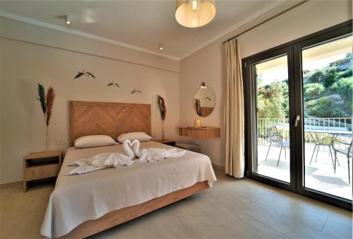 een slaapkamer met een bed en een glazen schuifdeur bij MERAVIGLIA in Parga
