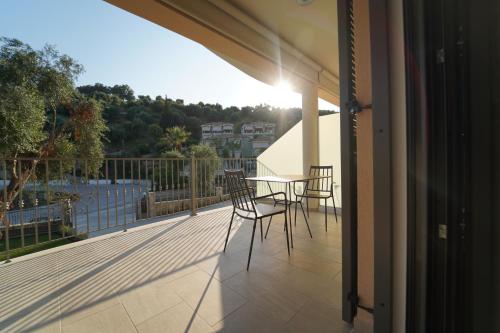 a patio with a table and chairs on a balcony at MERAVIGLIA in Parga
