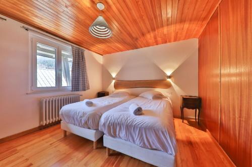 a bedroom with a bed and a wooden ceiling at Locations des 3 sommets avec Sauna et Spa en Alsace in Sondernach