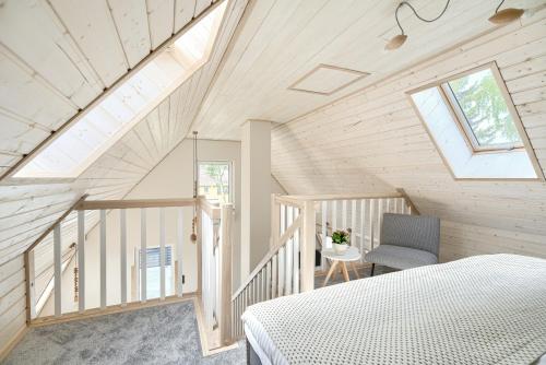 Schlafzimmer im Dachgeschoss mit einem Bett und einem Fenster in der Unterkunft Tucholska 3 in Tleń