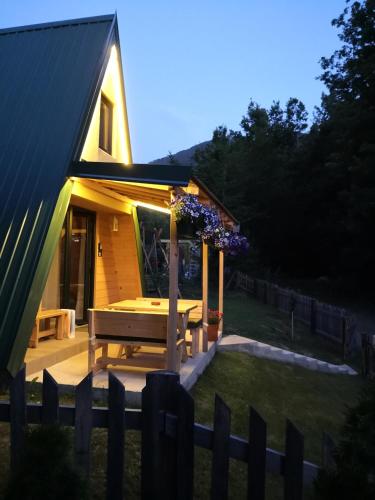 a small house with a picnic table in the yard at Koliba Pčelica 2 in Bijelo Polje