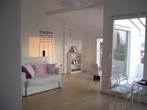 a living room with a white couch and chairs at Mala vila Punta Skala in Petrcane