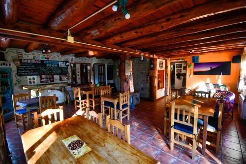 an empty restaurant with wooden tables and chairs at Hostel El Mirador in El Bolsón