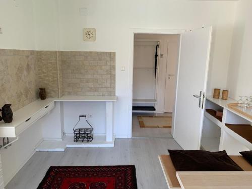 a white room with a door and a red rug at Sonnhügel Apartments - Ferienwohnungen in Faak am See