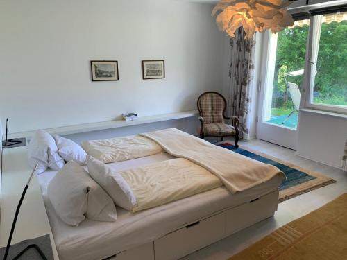 a bed in a bedroom with a large window at Sonnhügel Apartments - Ferienwohnungen in Faak am See