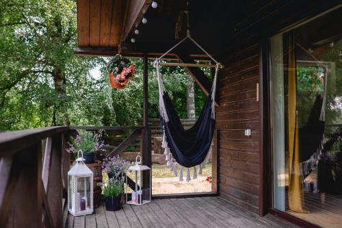 a hammock is hanging on a porch with plants at Mežmadaras in Kuldīga