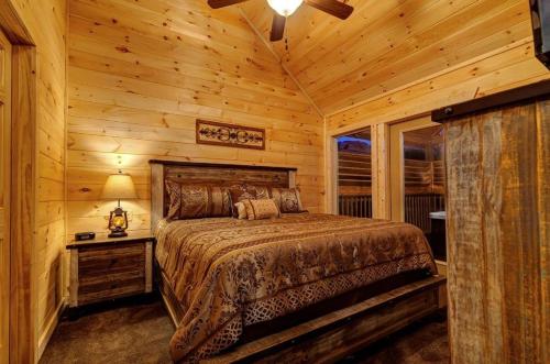 ein Schlafzimmer mit einem Bett in einem Blockhaus in der Unterkunft A Cozy Mountain Hideaway - 1 Bedrooms, 1 Baths, Sleeps 4 cabin in Sevierville
