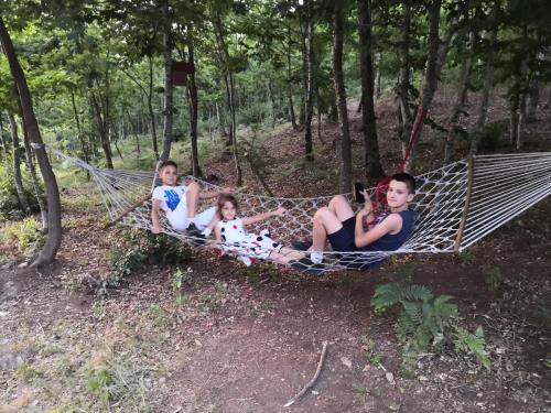 three people laying in a hammock in the woods at Koliba Pčelica 2 in Bijelo Polje