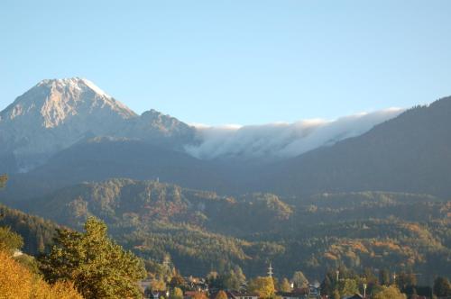 a mountain in the distance with a town in the foreground at Sonnhügel Apartments - Ferienwohnungen in Faak am See