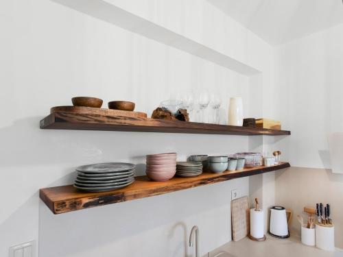 a kitchen shelf with plates and bowls on it at TatryView Apartments by KingDubaj in Veľká Lomnica