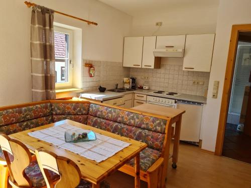 a living room with a couch and a table and a kitchen at Eselgut Pühringer in Hofkirchen im Mühlkreise