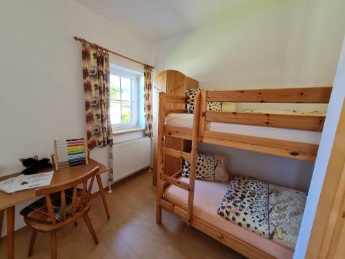 a bedroom with two bunk beds and a desk at Eselgut in Hofkirchen im Mühlkreise