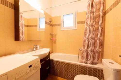 a bathroom with a sink and a tub and a toilet at Afroditi´s House in Ipsos
