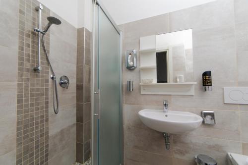 a bathroom with a sink and a shower at Hotel 21 Riccione in Riccione