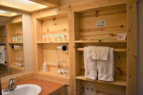 a wooden bathroom with a sink and towels at Methow River Lodge in Winthrop