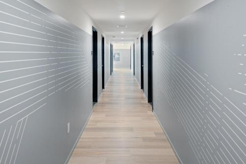 a long hallway with white walls and wooden floors at The Metric - Los Angeles Downtown in Los Angeles