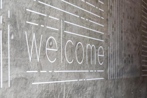 a sign with the word welcome written on the side of a building at The Metric - Los Angeles Downtown in Los Angeles